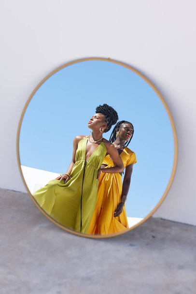 Shot of two beautiful womens reflection in a mirror outside. - Foto, Imagem