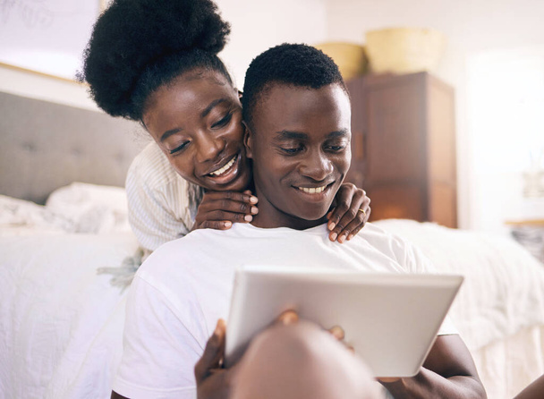 Fotografía de una joven pareja usando una tableta digital juntos en casa. - Foto, Imagen