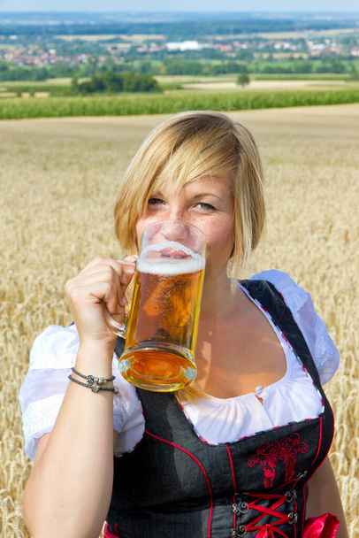 Młoda kobieta z kubkiem piwa w ręku - Zdjęcie, obraz