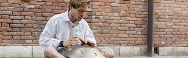 Street musician playing handpan in Venice, banner  - Photo, Image