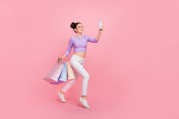 Full length body size view of beautiful cheery trendy girl using gadget buy goods isolated over pink pastel color background. - Foto, imagen