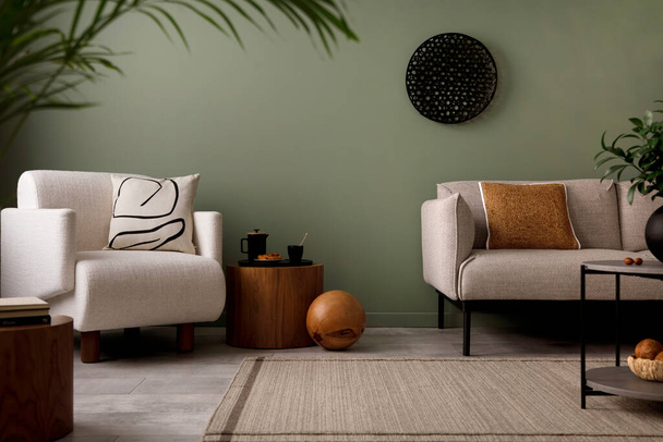 Stylish composition of living room interior with green wall, grey sofa with brown pillow. White armchair with patterned pilow, wooden coffee table with black accessories. Template. - Fotografie, Obrázek