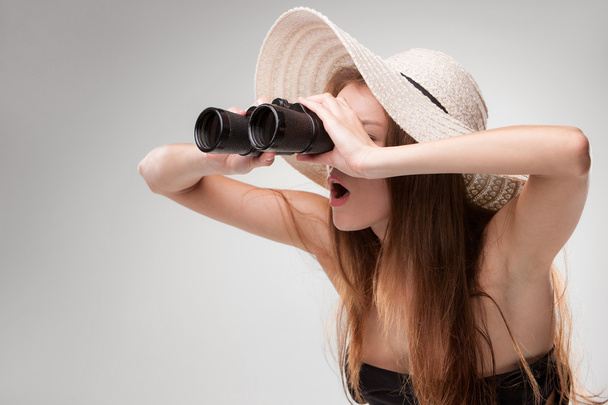 Young woman in hat with binoculars - Фото, изображение
