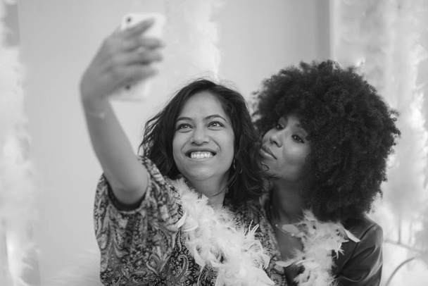 Pár mladých jižních asijských žena a africké americká žena baví brát selfie v baru. - Fotografie, Obrázek