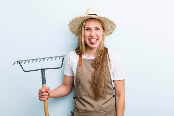 young blonde woman with a rake. farmer concept - Fotoğraf, Görsel