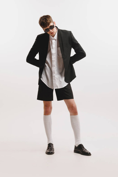 Portrait of young stylish man, student posing isolated over white studio background. Fashion male model in urban business style clothes. Concept of art, beauty, fashion, youth culture, sales and ads - Φωτογραφία, εικόνα