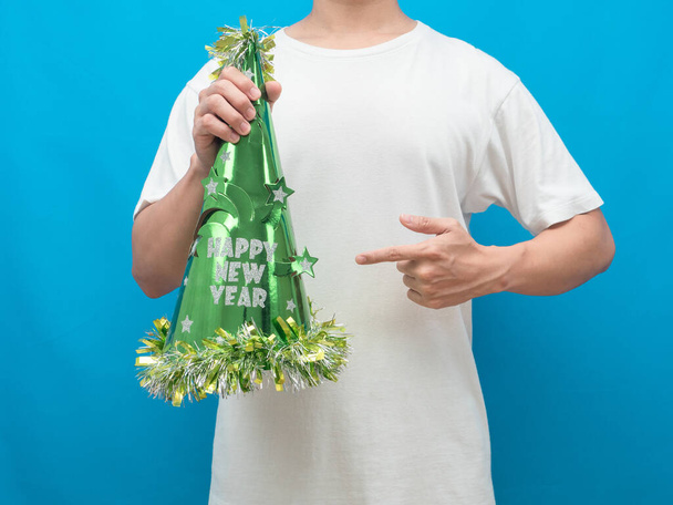 Man point finger at happy new year hat in hand blue background - 写真・画像