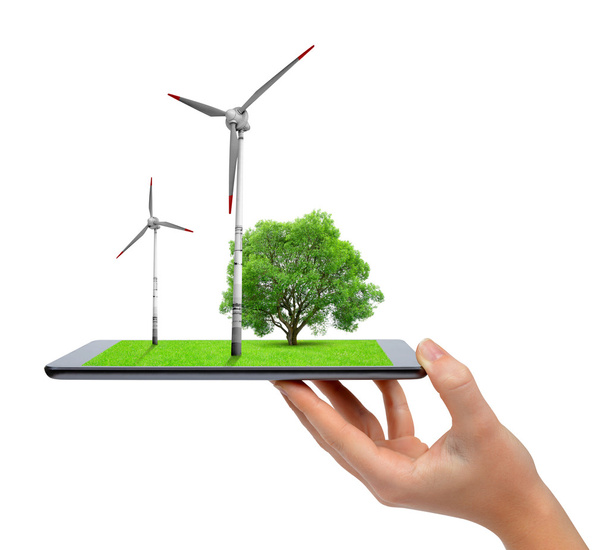 Hand holding digital tablet with a wind turbines and tree . - Photo, Image