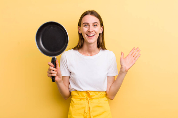 young adult pretty woman chef with a pan - Photo, image