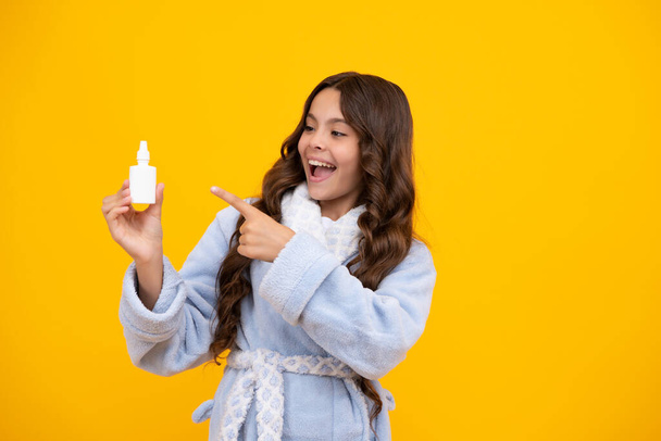Sick teen girl with nasal spray on yellow background. Amazed teen girl. Excited expression, cheerful and glad - Foto, Imagem