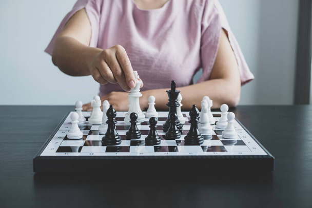 Рука предпринимательницы движется, шахматы в конкуренции показывает лидерство, последователей, и стратегии успеха бизнеса. - Фото, изображение