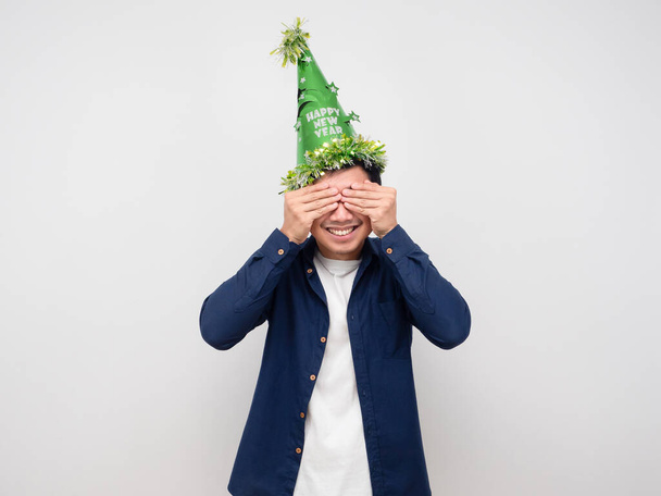 A zöld kalapos férfi becsukja a szemét ünneplés újévi koncepció - Fotó, kép