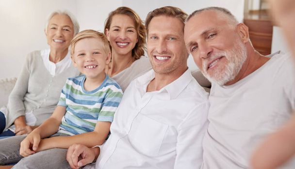 Portrait of happy generational caucasian family taking selfies at home. Little boy relaxing and bonding with carefree parents and grandparents while capturing photos and pictures for special memories. - Photo, Image