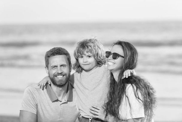szczęśliwa rodzina mama tata i dziecko na letniej plaży. - Zdjęcie, obraz
