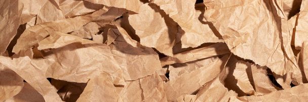 Multiple pieces of torn brown crumpled, wrinkled recycle craft paper background texture, top view banner. Wide panoramic header - Фото, зображення