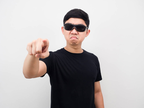 Азиатский мужчина в солнечных очках сердитый указывать пальцем на вас белый фон - Фото, изображение