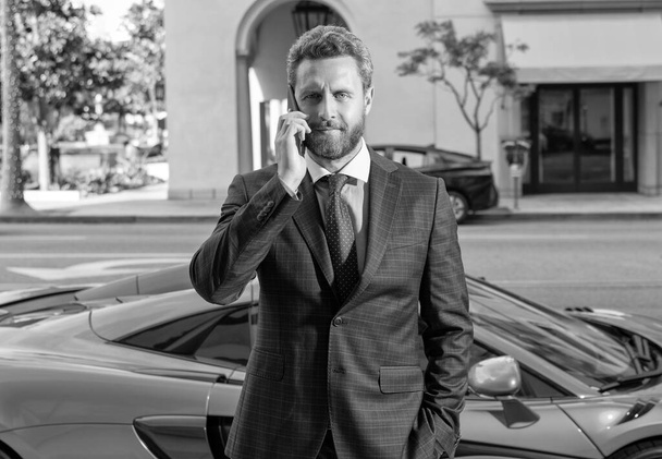 dealer man speak on smartphone next to the car. - Photo, Image