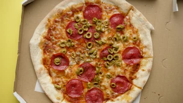 Fresh and hot Pizza pepperoni in a delivery box. Top view. Yellow background. - 映像、動画
