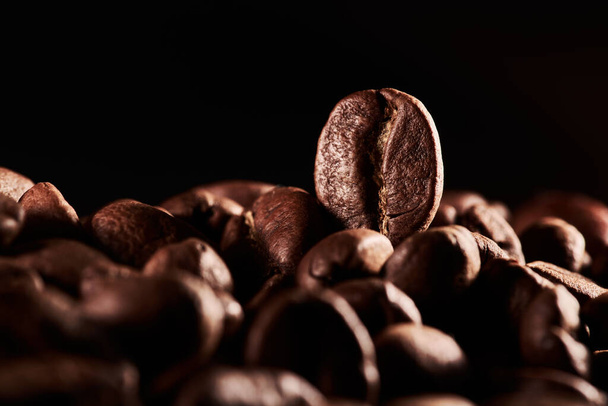 Roasted coffee beans isolated close up on black background, clipping path - Valokuva, kuva