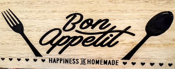 Bon Appetit sign with fork and spoon on wooden background - Foto, afbeelding