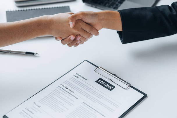 The job interviewer and the job applicant are holding hands after the job interview is finished. The concept of recruiting employees to work in the company, vacant positions. - Photo, Image
