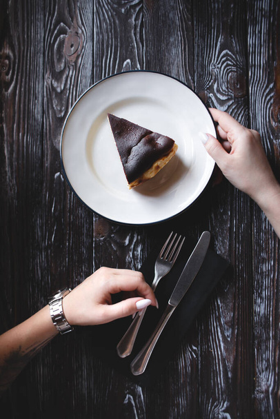 The confectioner's hand holds a piece of cake on the patisserie - Foto, Imagen