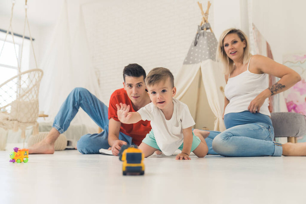 little cute Caucasian boy playing with his parents at home, full shot family relationship concept. High quality photo - Foto, immagini
