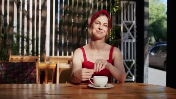 ragazza felice in un caffè beve caffè, divertimento in estate e stile di vita - Filmati, video