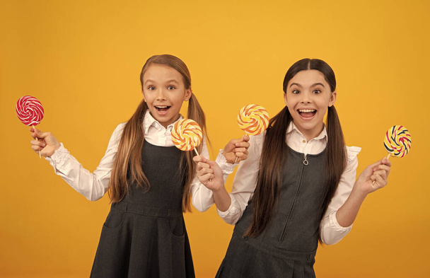 amazed teen girl in school uniform hold lollipop sweets, childhood. - Foto, afbeelding