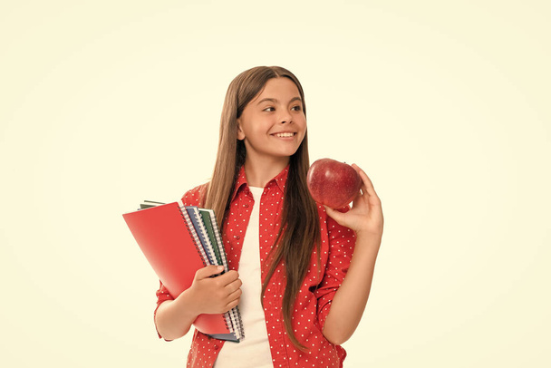 happy teenager student. high school education. schoolgirl with copybook. teen girl with notebook. back to school. child hold apple ready to study. healthy childhood. kid going to do homework. - Photo, Image