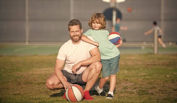щасливий батько і дитина грають в баскетбол з м'ячем на відкритому повітрі, спорт
. - Фото, зображення
