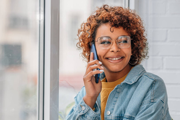 アフリカ系アメリカ人女性が携帯電話で話す - 写真・画像