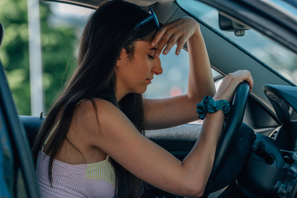 розчарована дівчина за кермом автомобіля через пробки або аварію
 - Фото, зображення