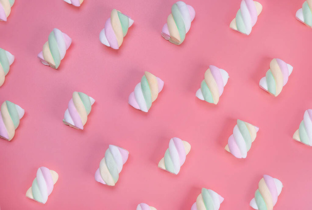 multi-colored chewy marshmallows on a pink background, the concept of a birthday, holiday, fun, trendy sweet background.  - Фото, изображение