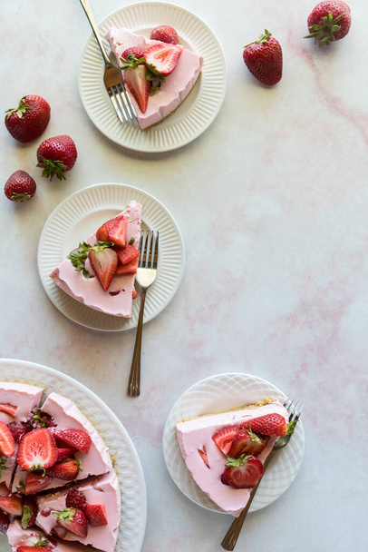 Top down view of slices of homemade strawberry cheesecake with copy space to the right.  - Fotó, kép