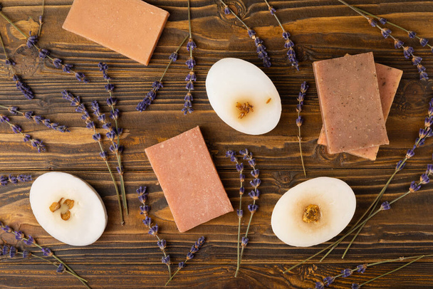 Natural lavender soap with lavender flowers on a brown wooden background.Handmade Soap.Cosmetic product with essential oils.spa product.Space for text. Flat lay. - Fotó, kép