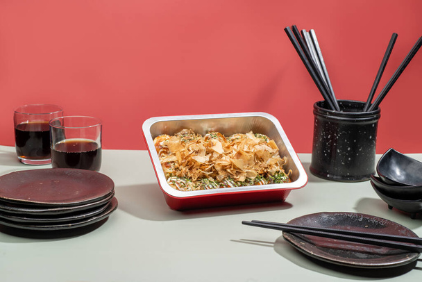TAKOYAKI food tray with drinks and chopsticks isolated on grey background side view - Foto, Bild