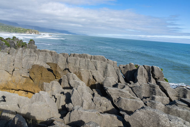 Stratified layer-like formation of famous pancake rocks famous geological formation on coast at Punakaiki, on West Coast South Island New Zealand. - Fotografie, Obrázek