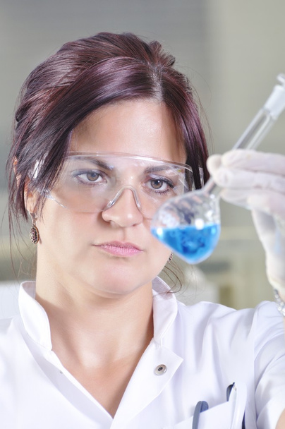 Atractivo joven científico estudiante de doctorado observando la indica azul
 - Foto, Imagen