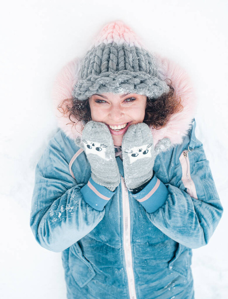 Beautiful smiling woman has fun outdoors. Woman in snowy forest.  - Fotó, kép