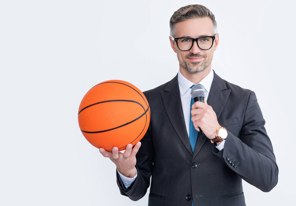 happy mature man in suit hold basketball ball and microphone isolated on white background. - Foto, Bild