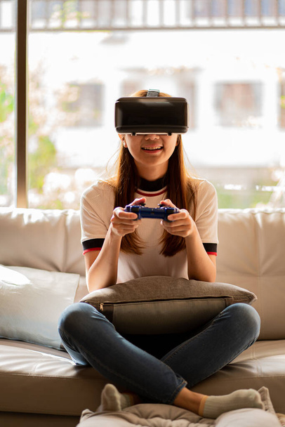 Азійська жінка використовує vr-окуляри, 3D-шолом віртуальної реальності на SOPA, концепцію віртуальної реальності, симуляцію, ігри і технології майбутнього. Азійські жінки грають в ігри в кімнаті. - Фото, зображення