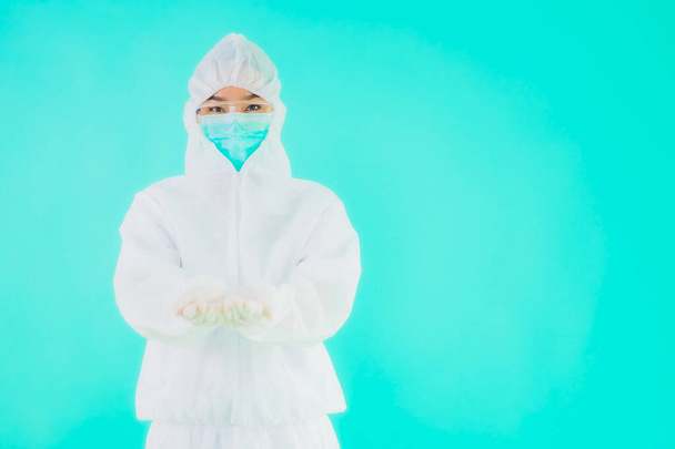 Retrato hermosa joven asiática médico mujer usar ppe o equipo de protección personal para proteger de coronavirus o covid19 sobre fondo aislado azul
 - Foto, Imagen