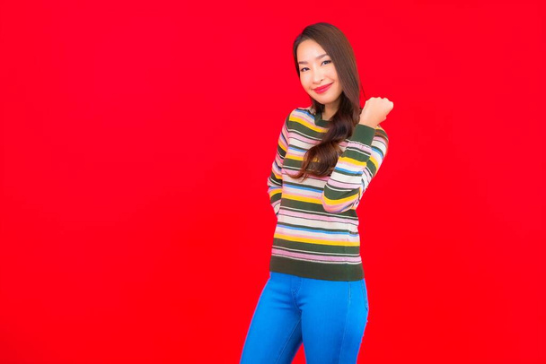 Retrato bonito jovem asiático mulher sorriso com ação no vermelho isolado fundo - Foto, Imagem