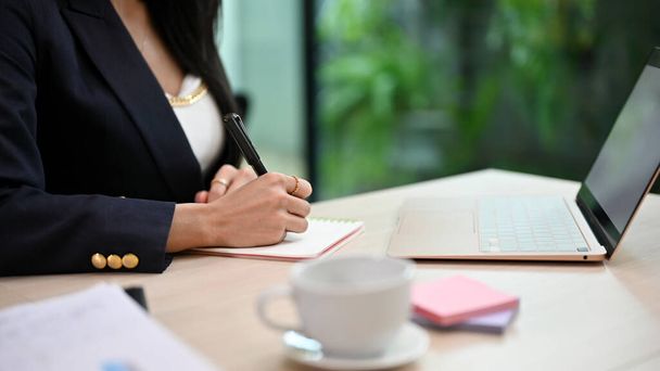 Sikeres üzletasszony vagy női ügyvezető igazgató, aki az asztalánál írja vagy írja alá a dokumentumot. vágott és fókuszált kéz. - Fotó, kép
