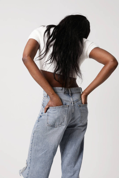 Back view of young woman wearing a casual cloths posing indoor. Vertical mock-up. High quality photo - Φωτογραφία, εικόνα