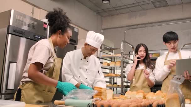 Vedoucí týmu zaměstnanců, kteří dělají chleba těsto a pečivo potraviny jsou zaneprázdněny s domácími pečení pracovních míst při vaření objednávky on-line, balení, a dodání na pekařství obchod, malé podniky podnikatele. - Záběry, video