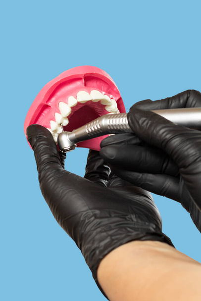 Голова высокоскоростного зубного наконечника с буром и компоновкой челюсти в руках дантиста. Стоматологические инструменты для лечения зубов. Крупный план. - Фото, изображение