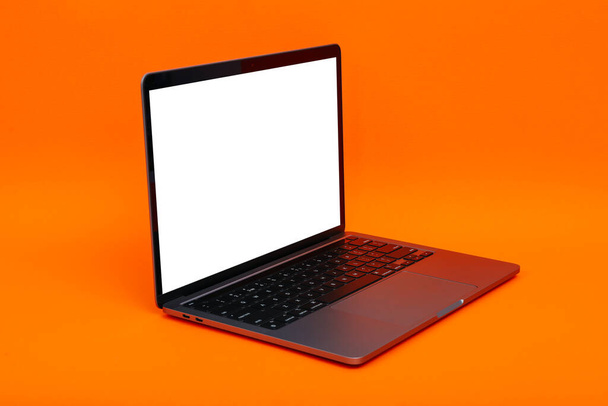 Turuncu arkaplanda boş ekran olan dizüstü bilgisayar - Fotoğraf, Görsel