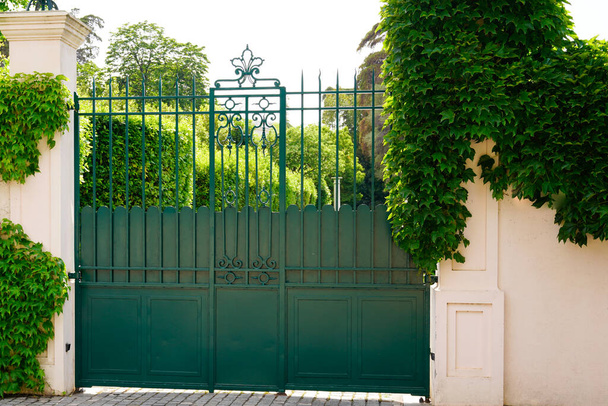 πράσινη vintage πόρτα σπίτι και γκαράζ πόρτα για να αποκτήσετε πρόσβαση στο σπίτι κήπο - Φωτογραφία, εικόνα
